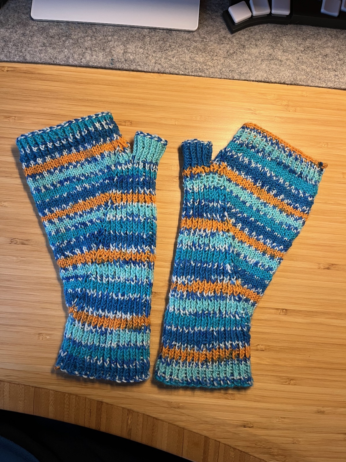 Knitted fingerless mittens in striped yarn.