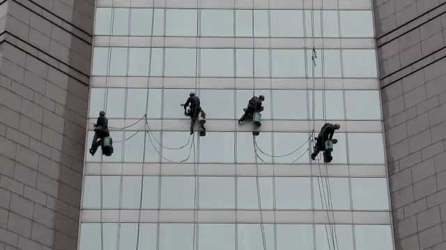 Shanghai, Window Cleaner cleaning a Glass Façade of a Department Store China, 2000s