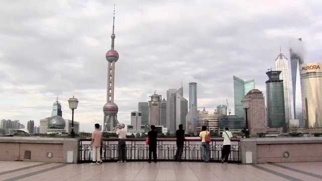Shanghai, Skyline of Pudong with the Oriental Pearl TV Tower and the Huangpu River and Tourists enjoying the Sight China, 2000s