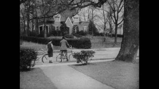 Father and Son Riding Bicycles, Making Signals, USA, 1930s