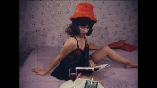 Nudie Film, Striptease, Woman with Red Hat in Bed, USA, 1960s - 070386