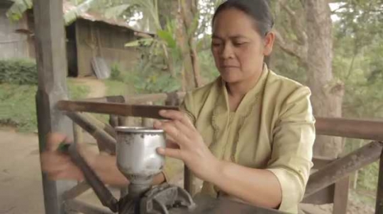 Woman Hand-Operating Coffee Grinder, Indonesia, 2010s