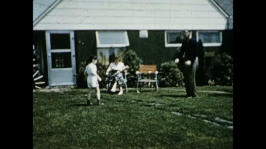 Father Playing Catch with Daughter in Front of House, USA, 1950s