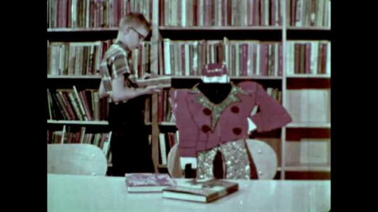 Boy Reading Book at Library, USA, 1960s