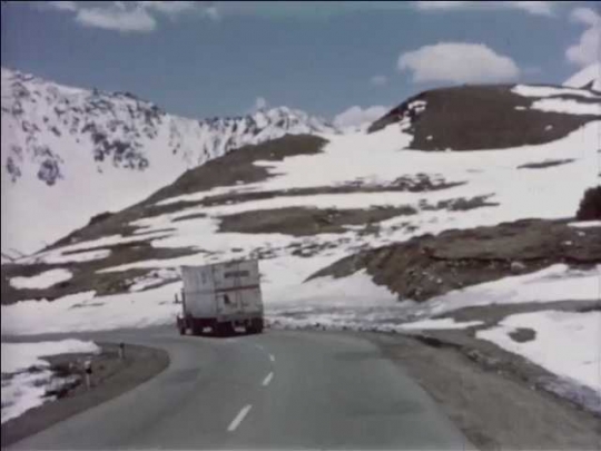 Truck Driving Through Snowy Mountain Landscape, USA, 1950s