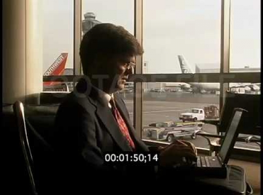 Business Man Working on Laptop Computer at Airport Terminal, USA, 2000s