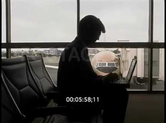 Business Man at Airport Terminal, Working on Laptop, Talking on Cellphone, USA, 2000s