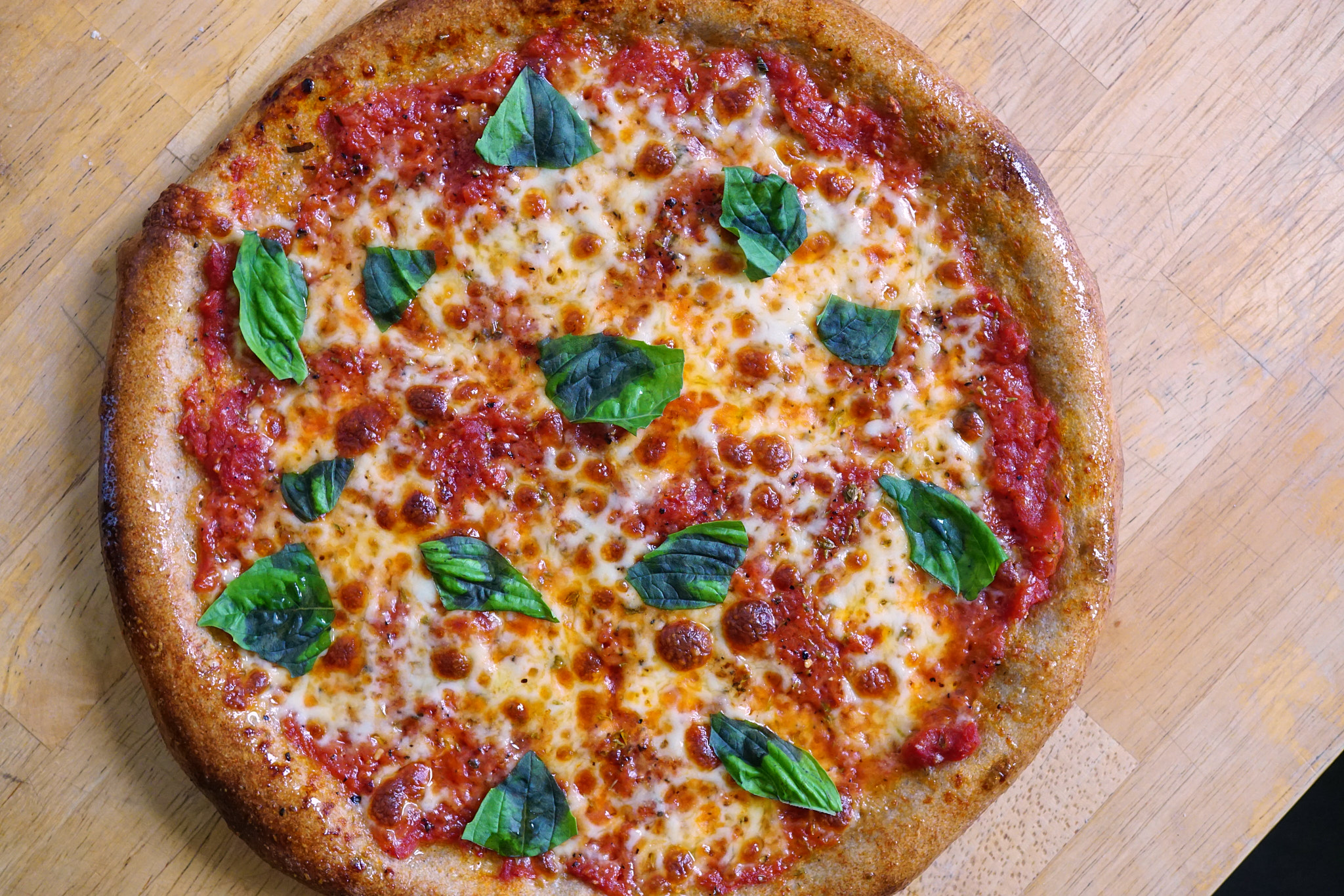 Image of Top with torn basil and a small drizzle of olive...
