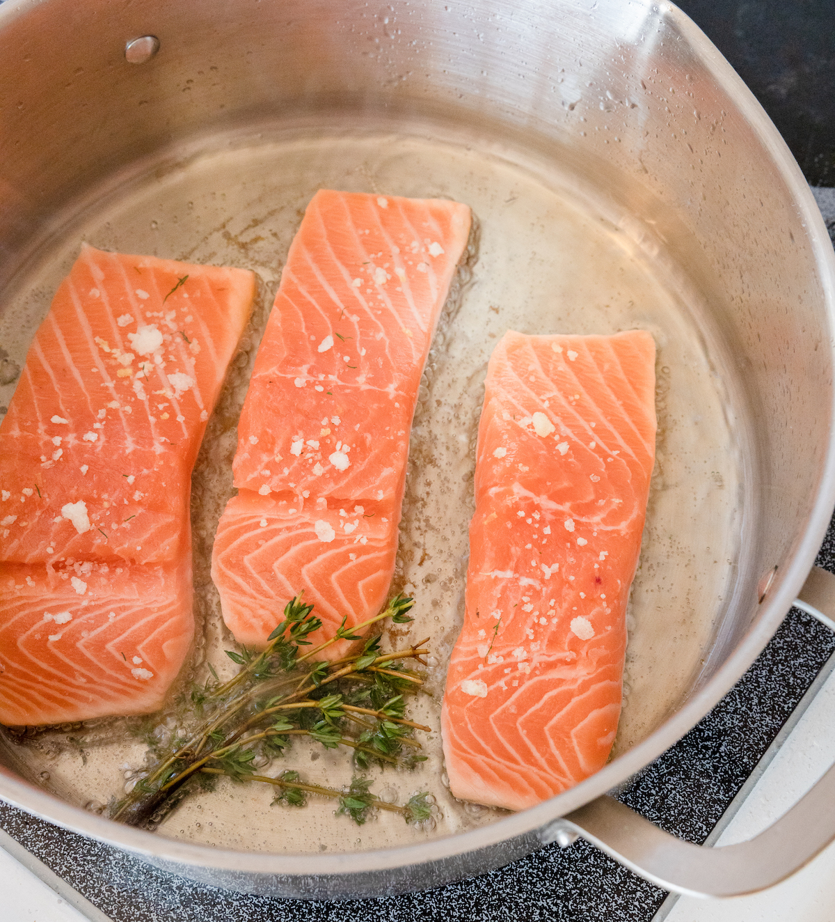 Image of Gently place each salmon fillet in the pan, leaving adequate...