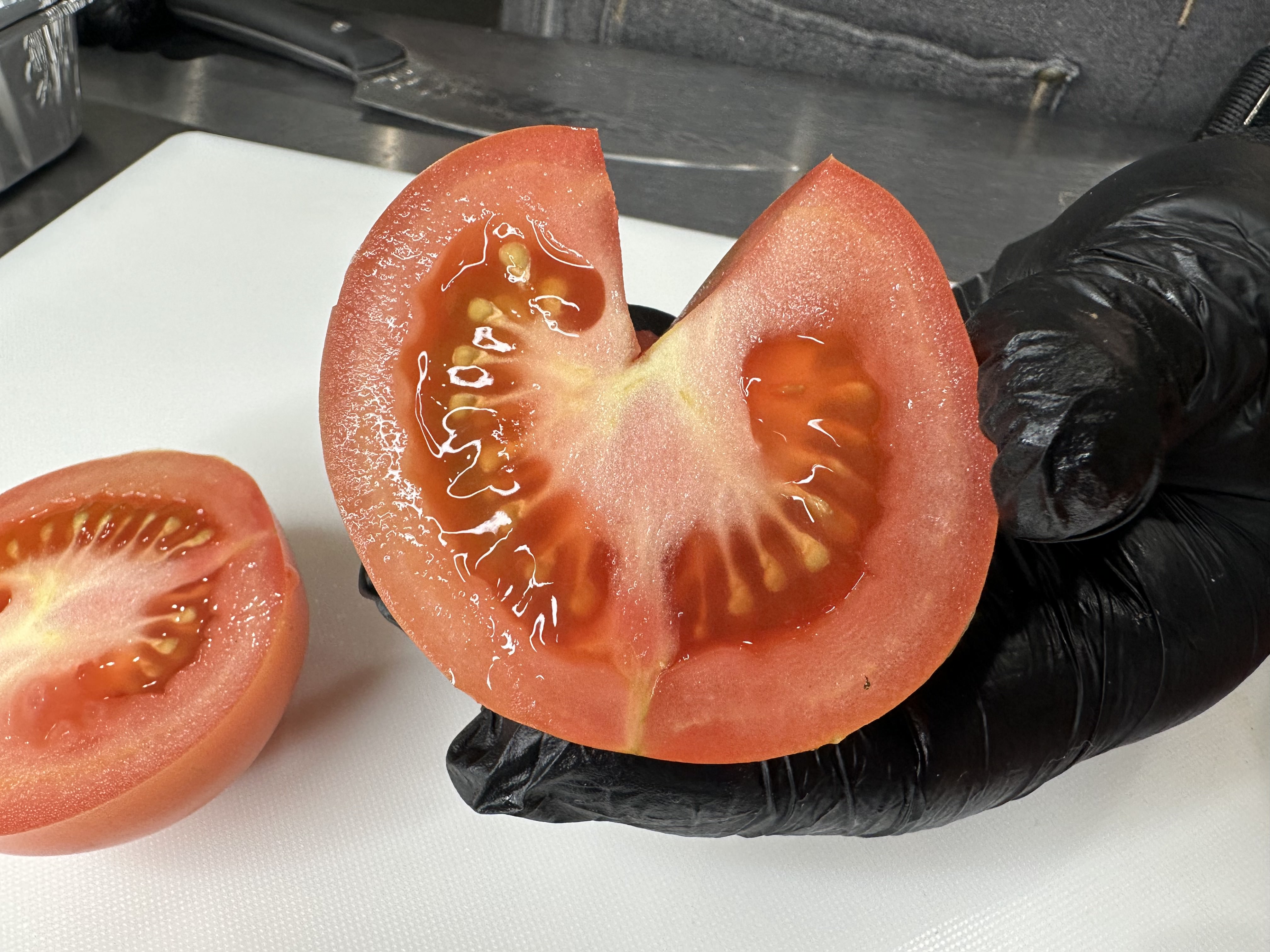 Image of Slice tomatoes in half and remove small core where the...