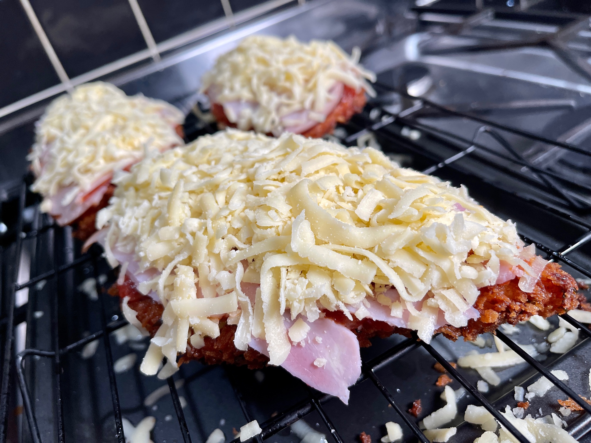 Image of Add sauce on top of schnitty, then ham, and cheese