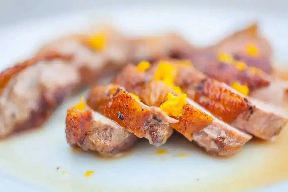 Image of Slice each duck breast and top with the orange zest....