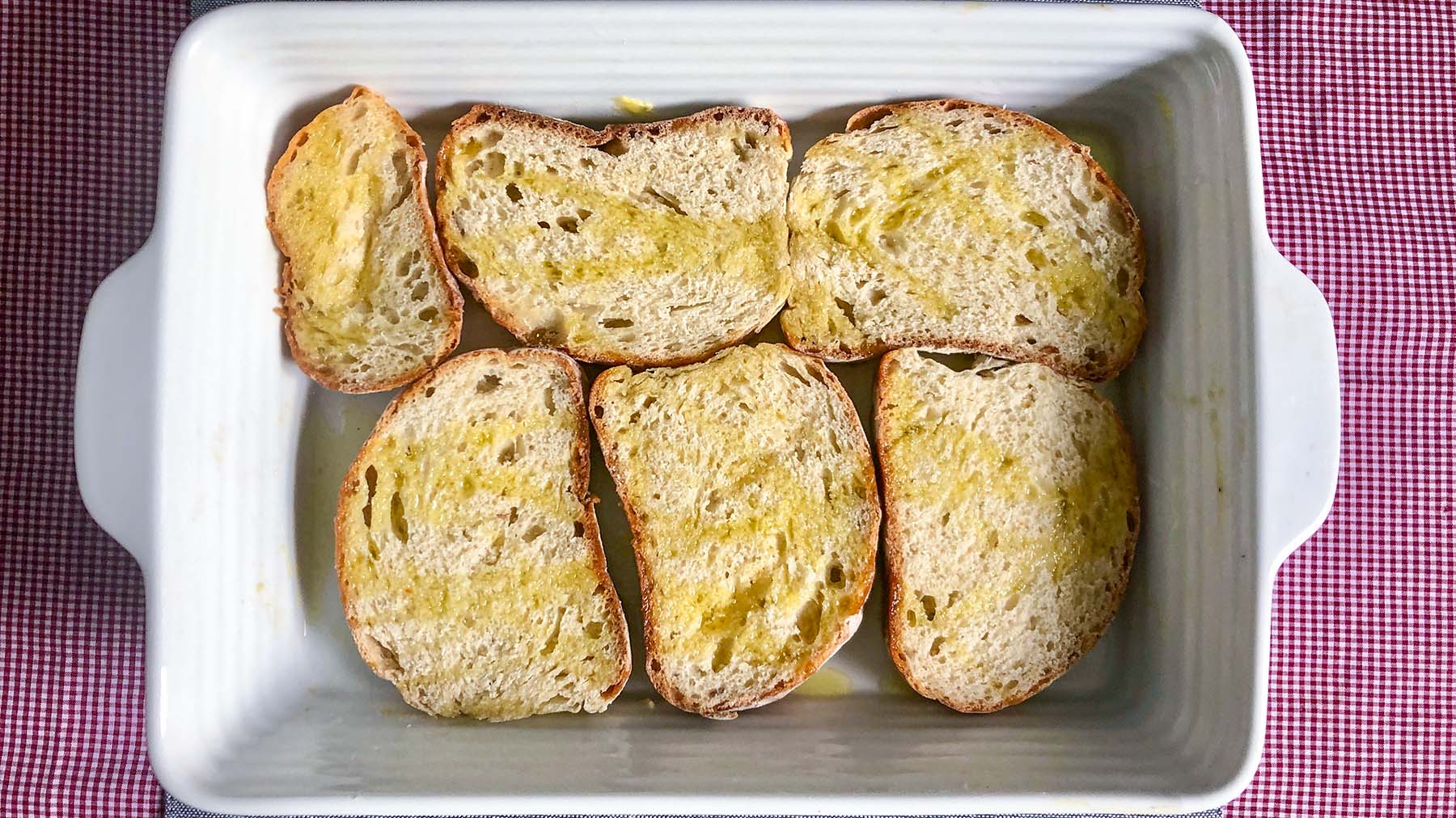 Image of Grease a 9x13-inch pan. Butter bread sliced and lay in...