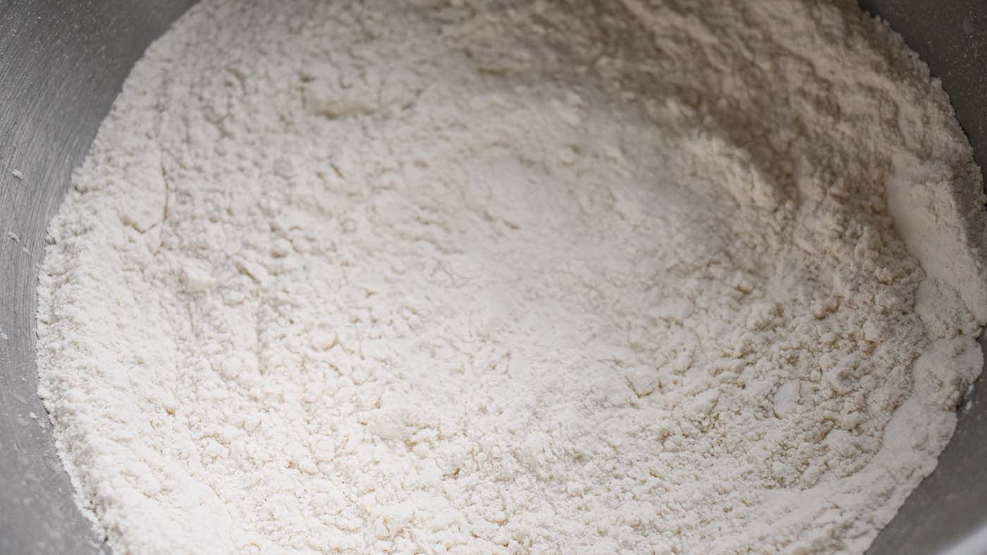 Image of In a large mixing bowl, sift together sugar, baking powder,...