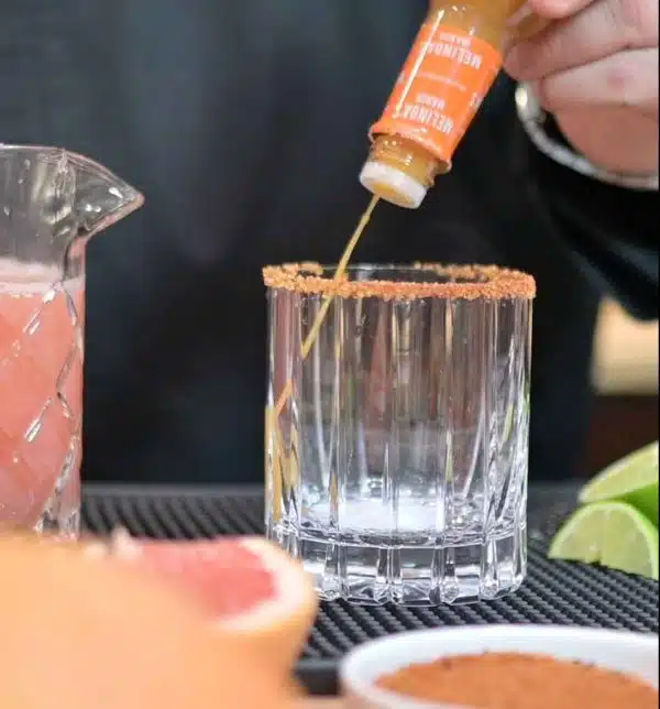 Image of Rim your glass with seasoning. Mix the hot sauce, grapefruit...