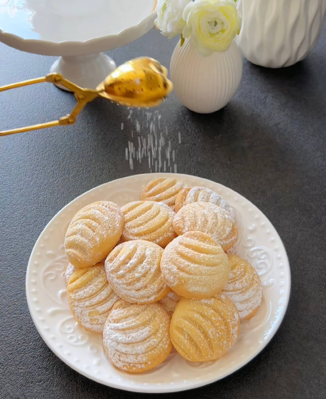 Image of Allow the cookies to cool on the baking sheet. Dust...