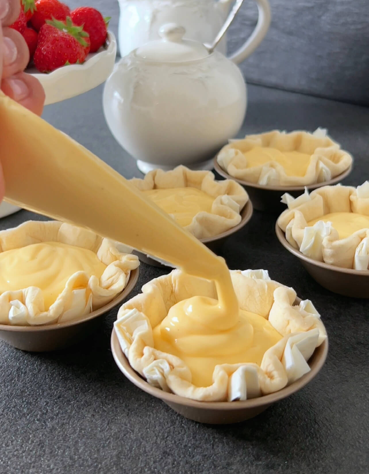 Image of Evenly distribute the prepared quark filling into the tarts.