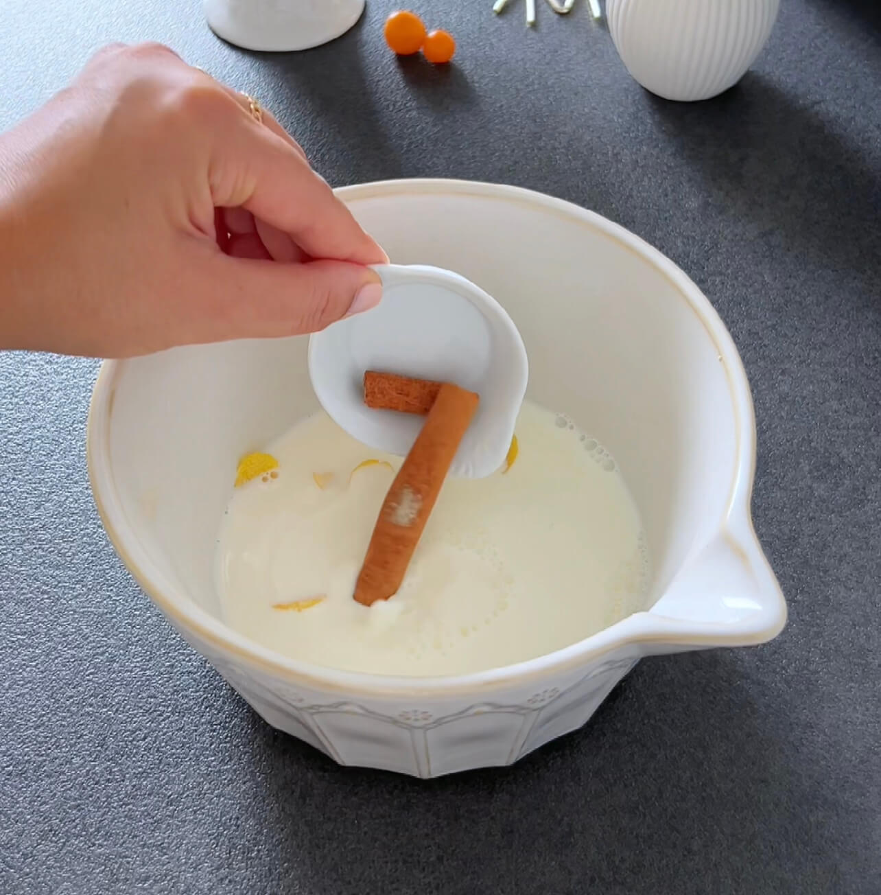 Image of Add cinnamon sticks and lemon peels to a small pot....