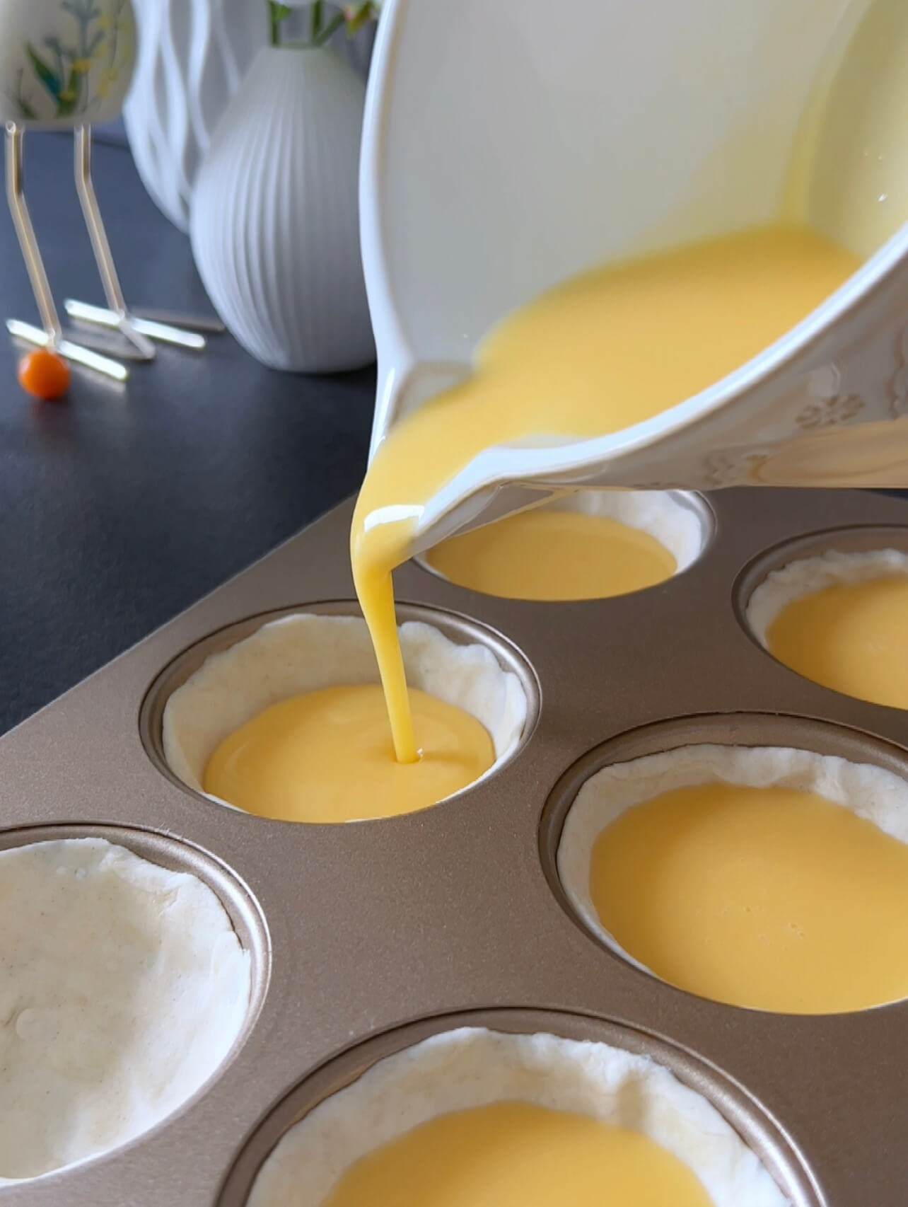 Image of Take the prepared muffin tin and evenly pour the pudding...