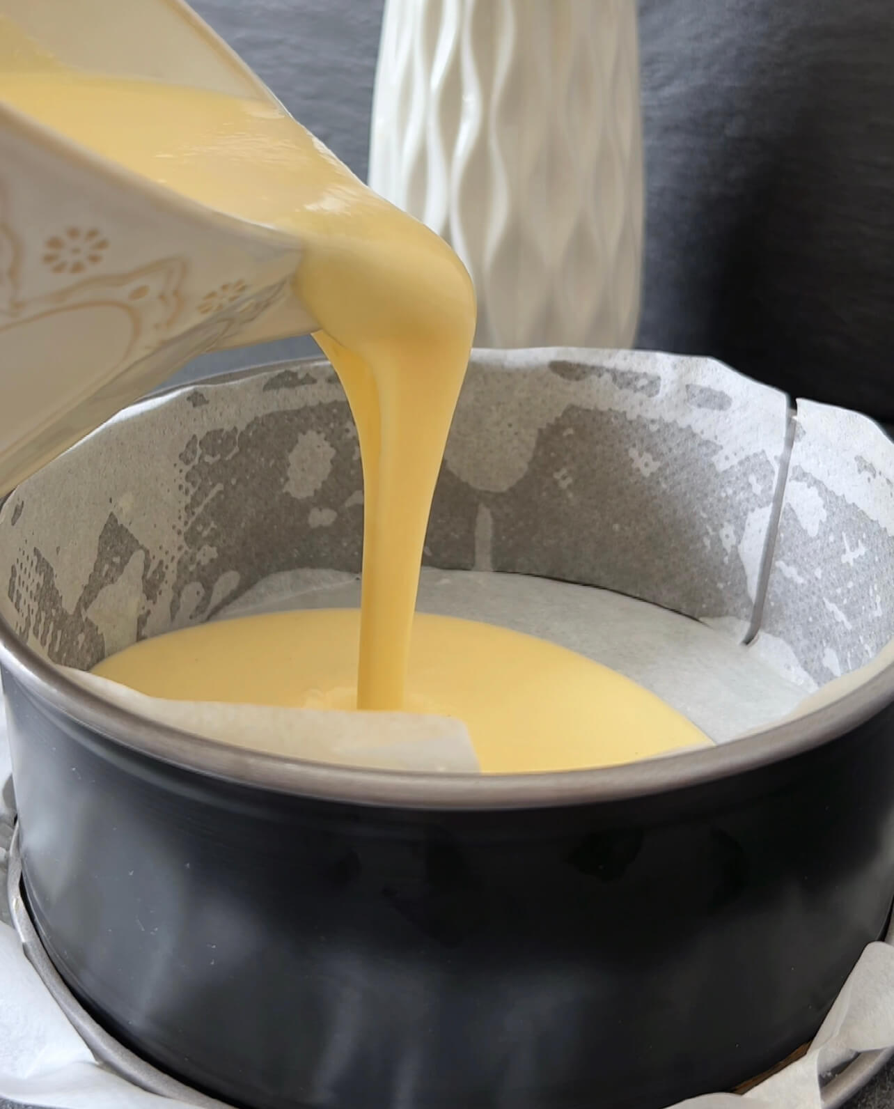 Image of Pour the cheesecake mixture into the prepared pan.