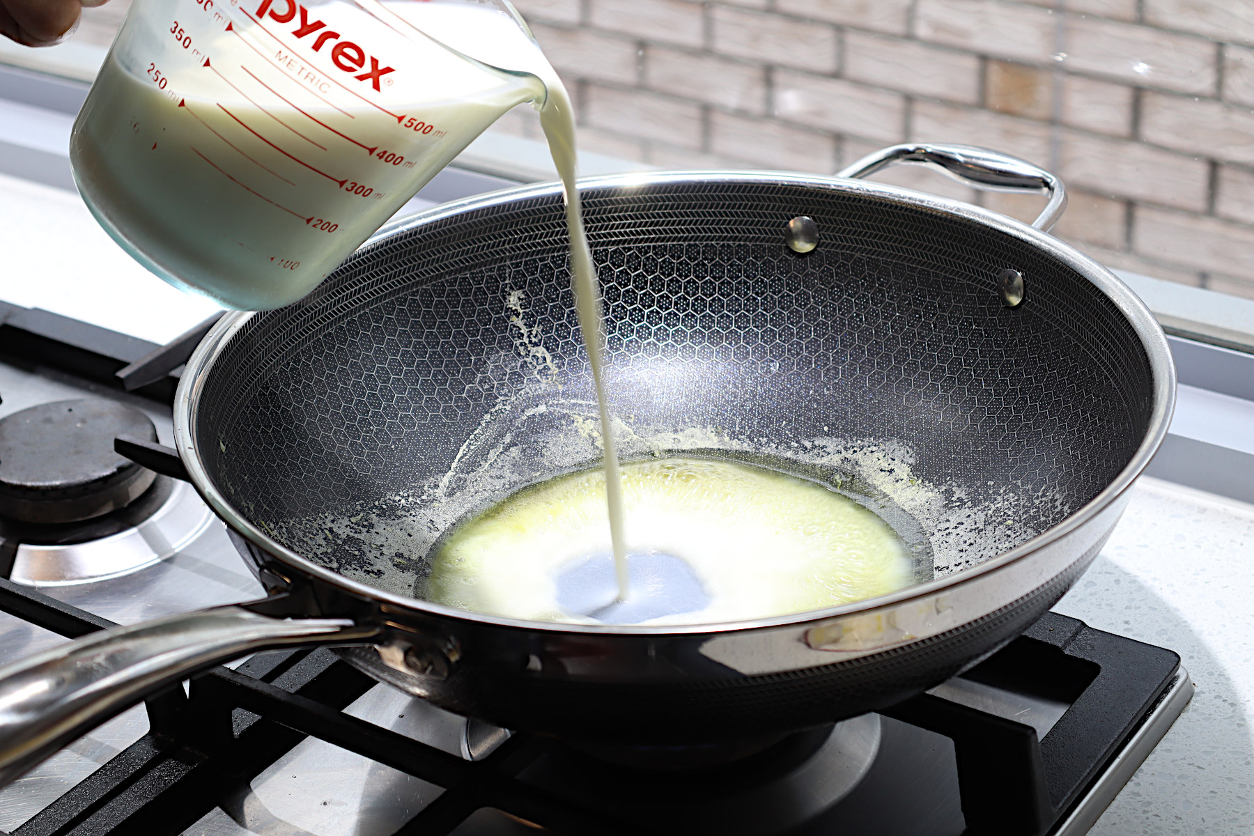 Image of pan on low-medium heat, then add milk and stir through