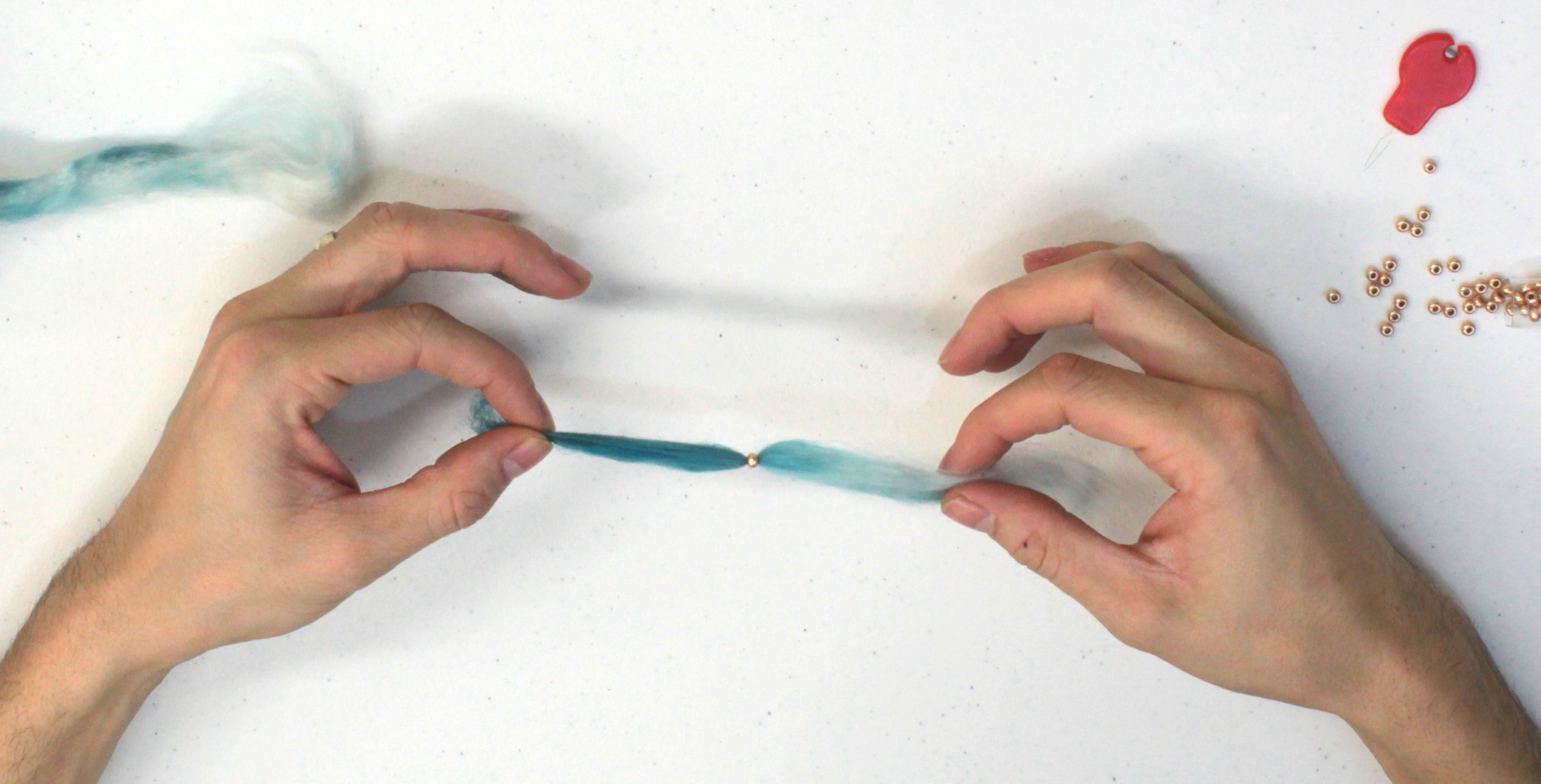Image of Using the needle threader, slip the fiber through the hole...