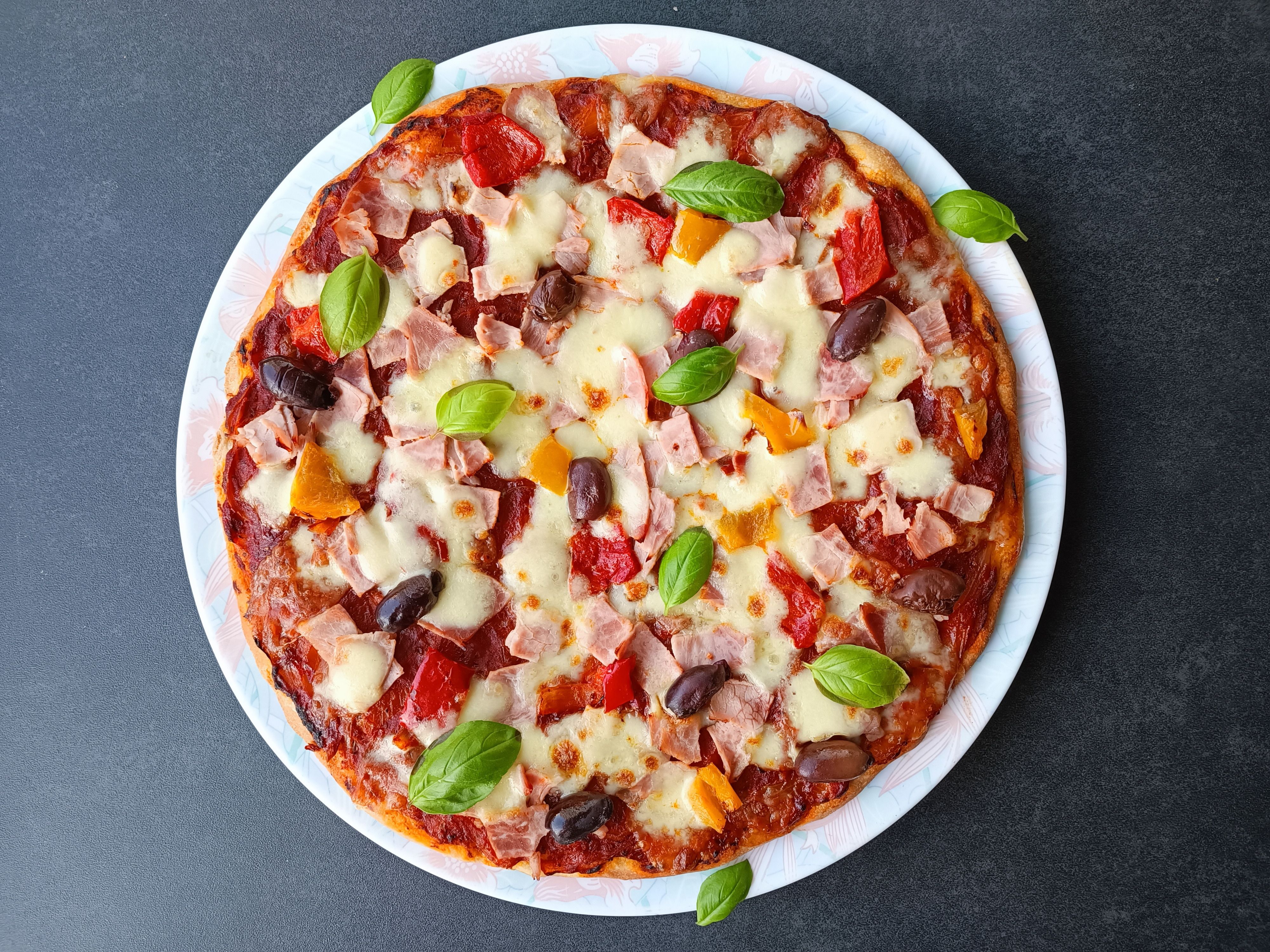 Image of Placer la pizza sur le plat de service. Décorer avec...