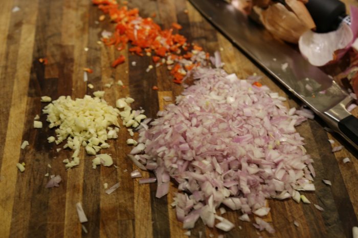 Image of Mince shallots, habaneros and garlic and set aside.