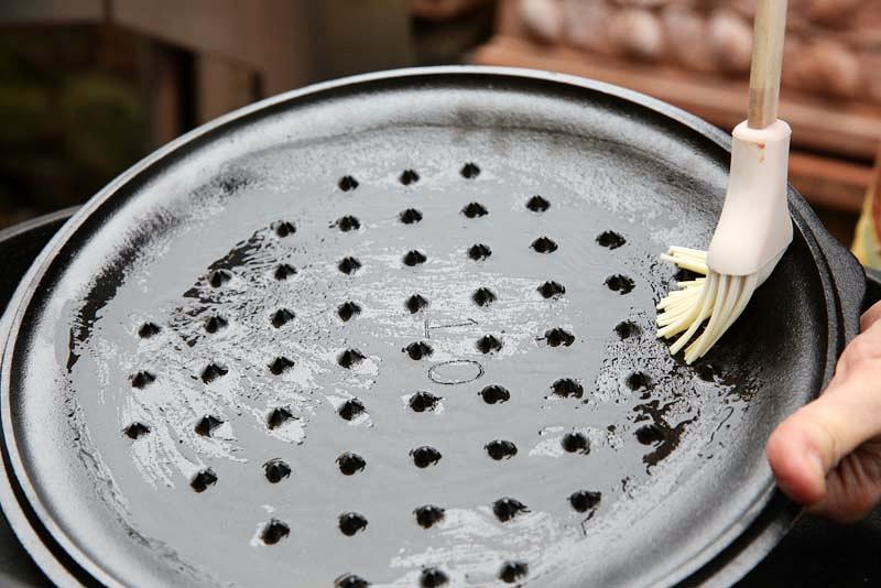 Image of Carefully remove the cast iron skillet and lid from the oven. With...