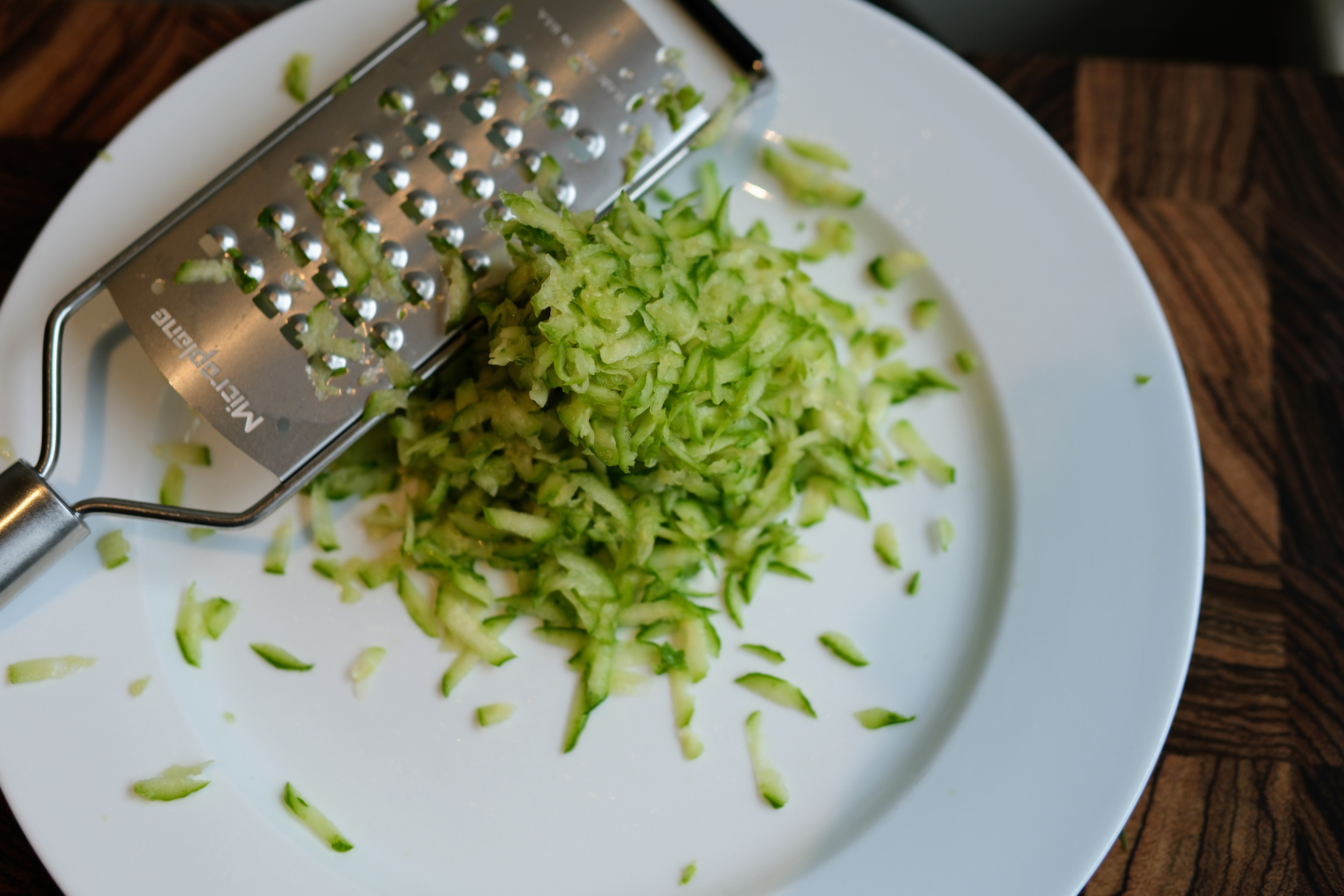 Image of Grate cucumbers with skin on using a large grater.