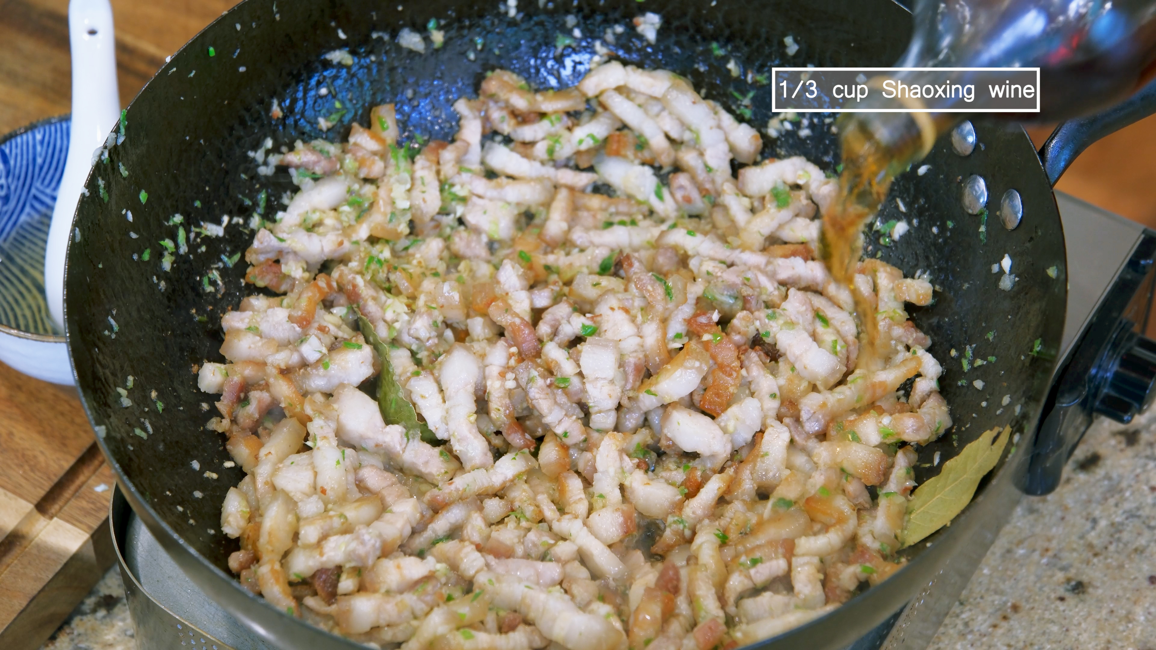 Image of Pour in 1/3 cup of Shaoxing wine and stir to deglaze...