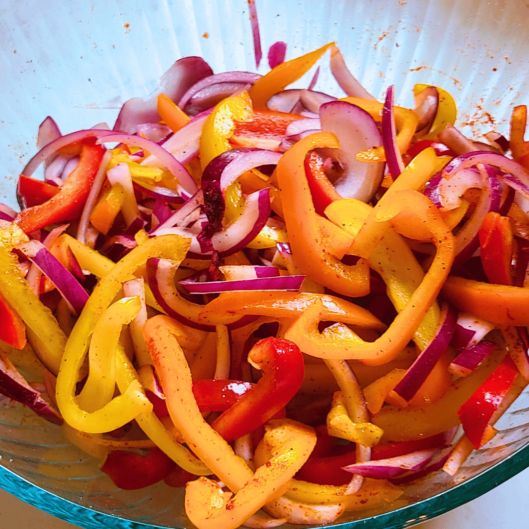 Image of Slice the onions and peppers into thin strips then toss...