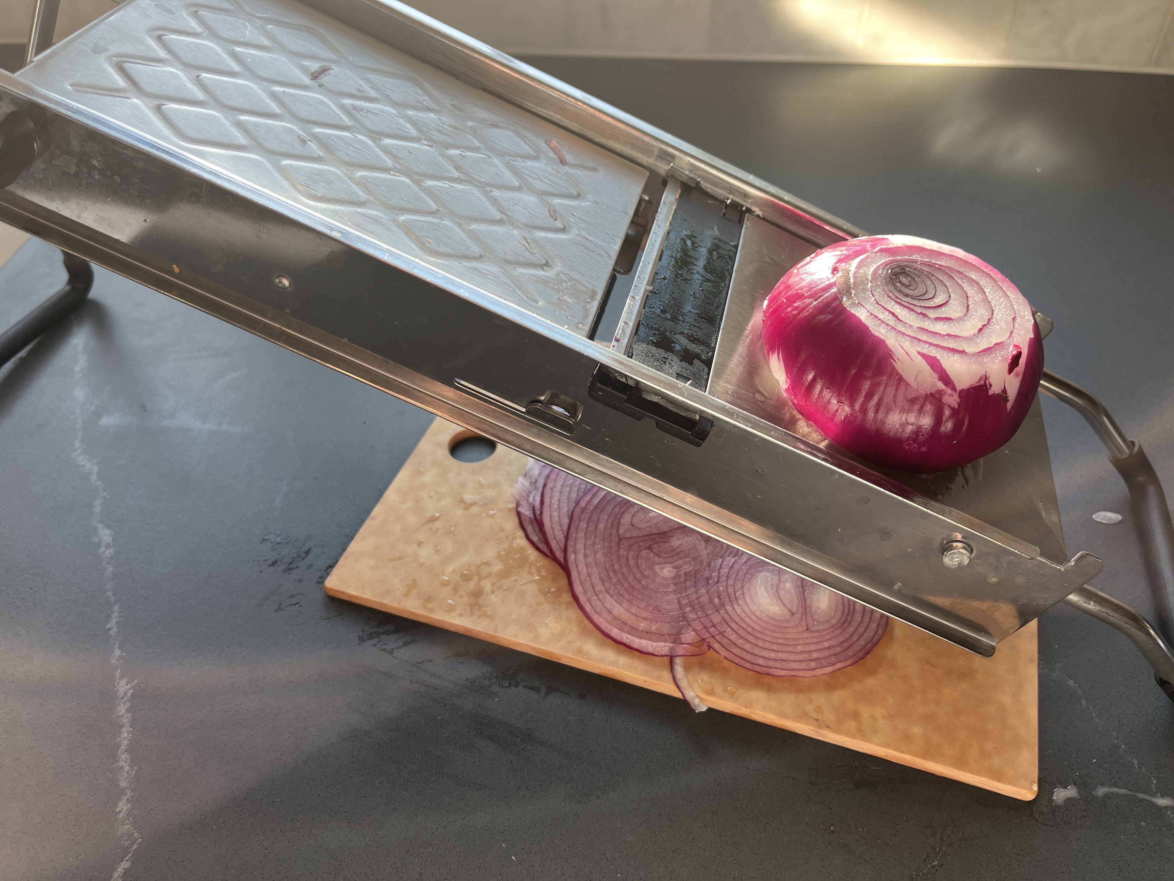 Image of Thinly slice the onions using a mandoline.