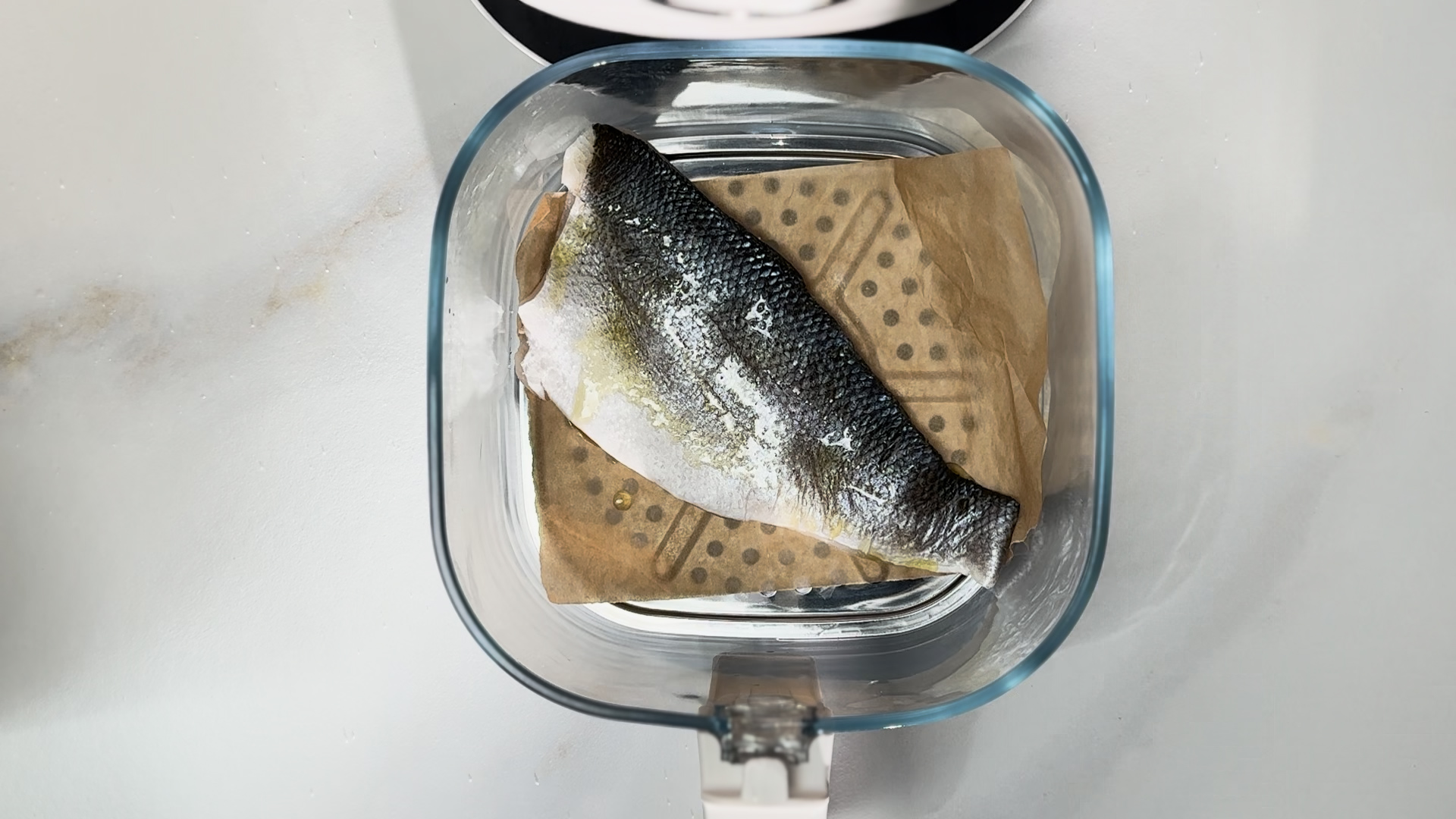 Image of Cook the branzino: Line your air fryer pan with parchment...