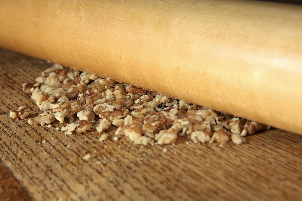 Image of With a rolling pin slightly crush the walnuts.