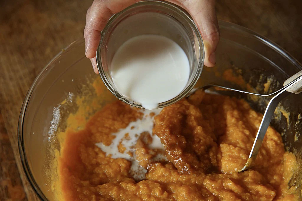 Image of Pour 1/3 cup milk over the sweet potatoes.