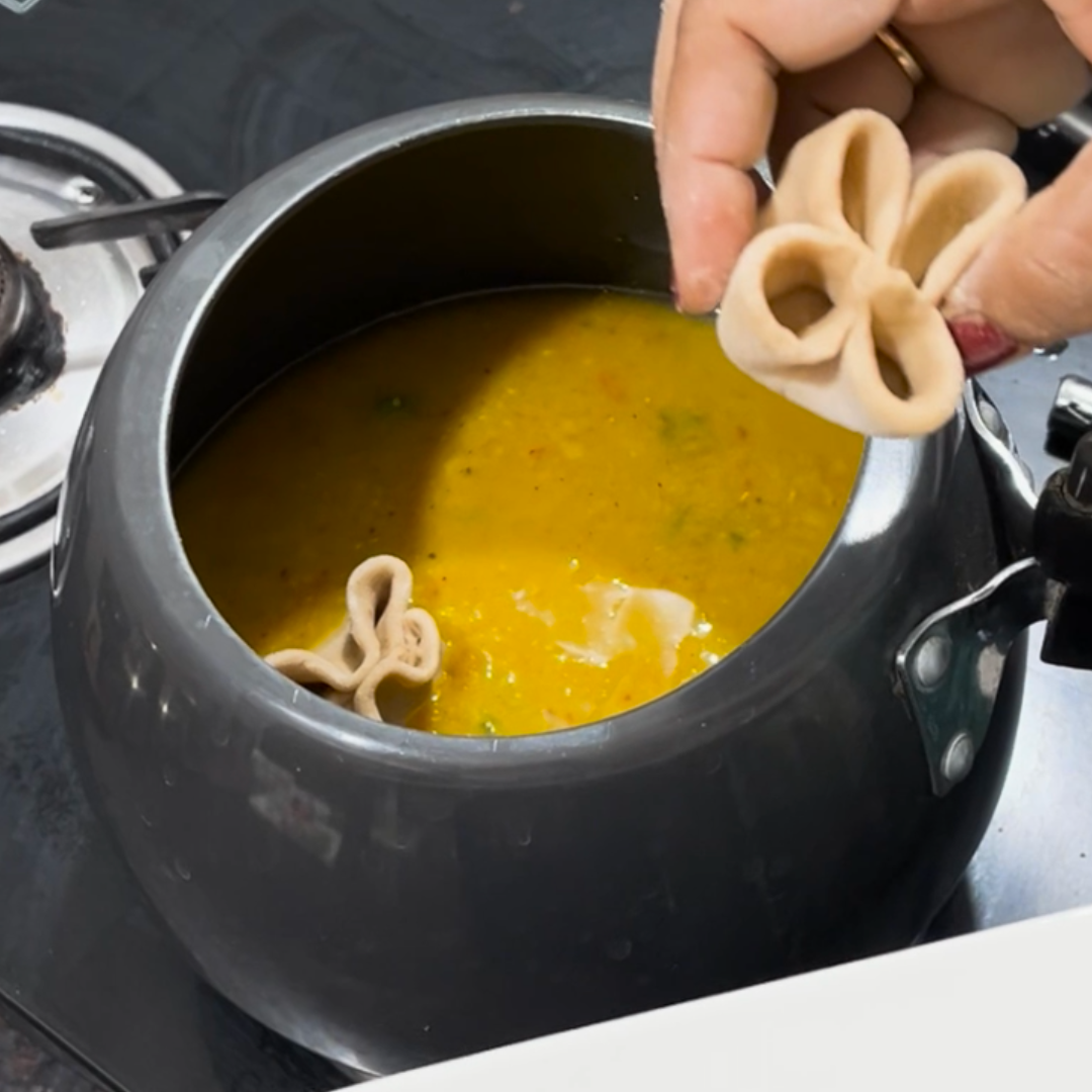 Image of Gently drop the prepared dumplings into the simmering dal one...