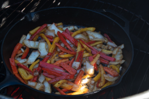 Image of Place veggies into the cast iron pan on the smoker,...