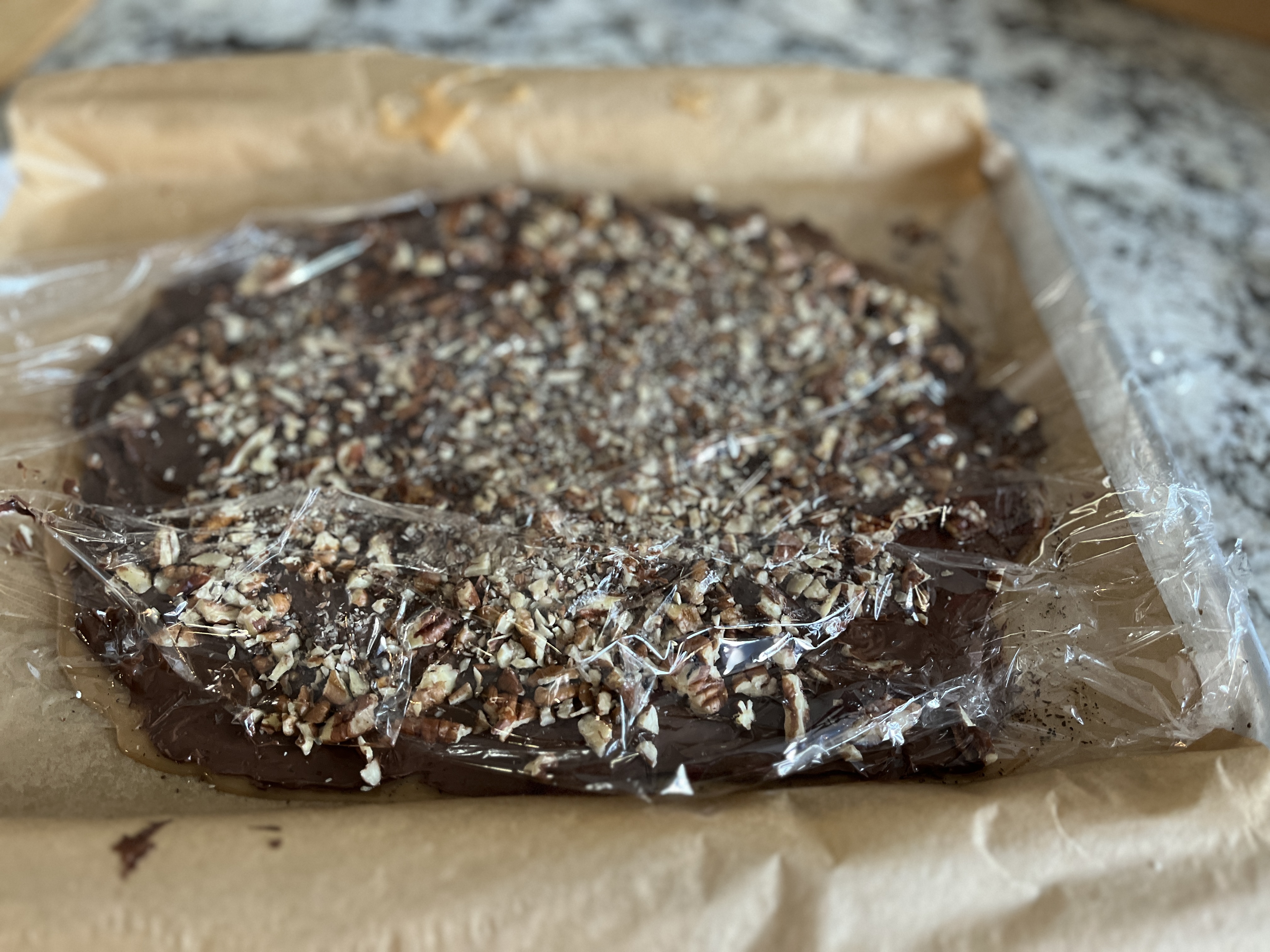 Image of Using a piece of plastic wrap, press the pecans gently...