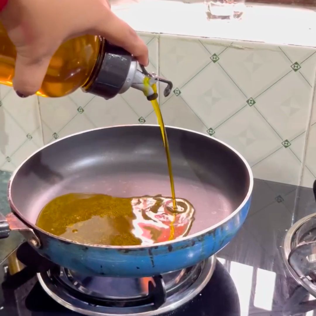 Image of Heat Mustard oil in a deep frying pan on medium...