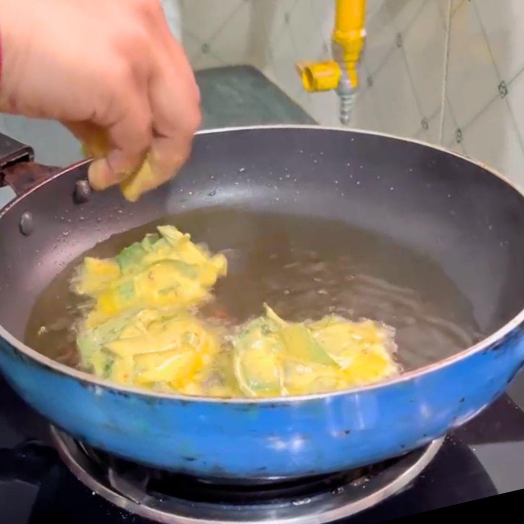 Image of Gently slide the batter-coated leaves into the hot oil, a...