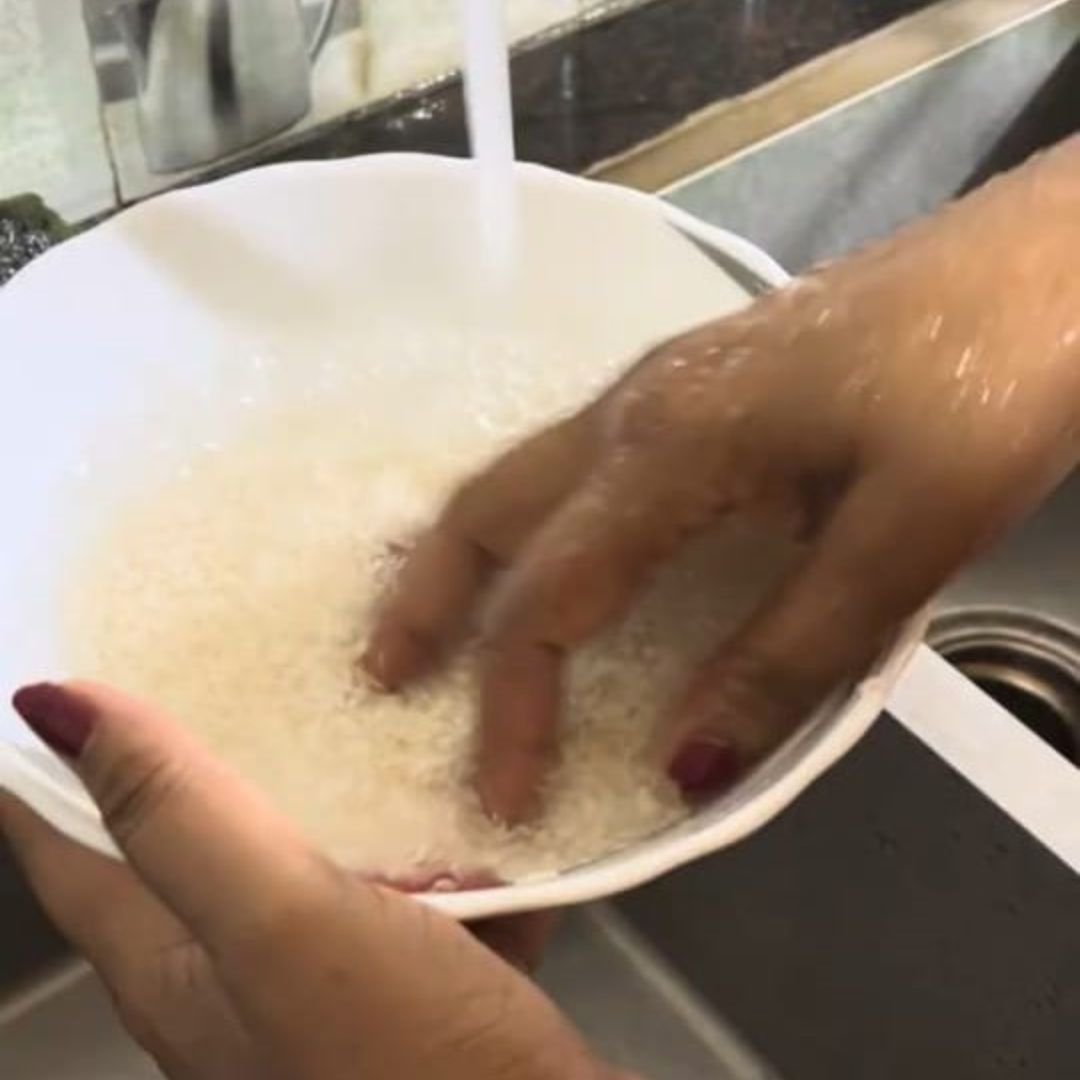 Image of Rinse the rice thoroughly under running water until the water...