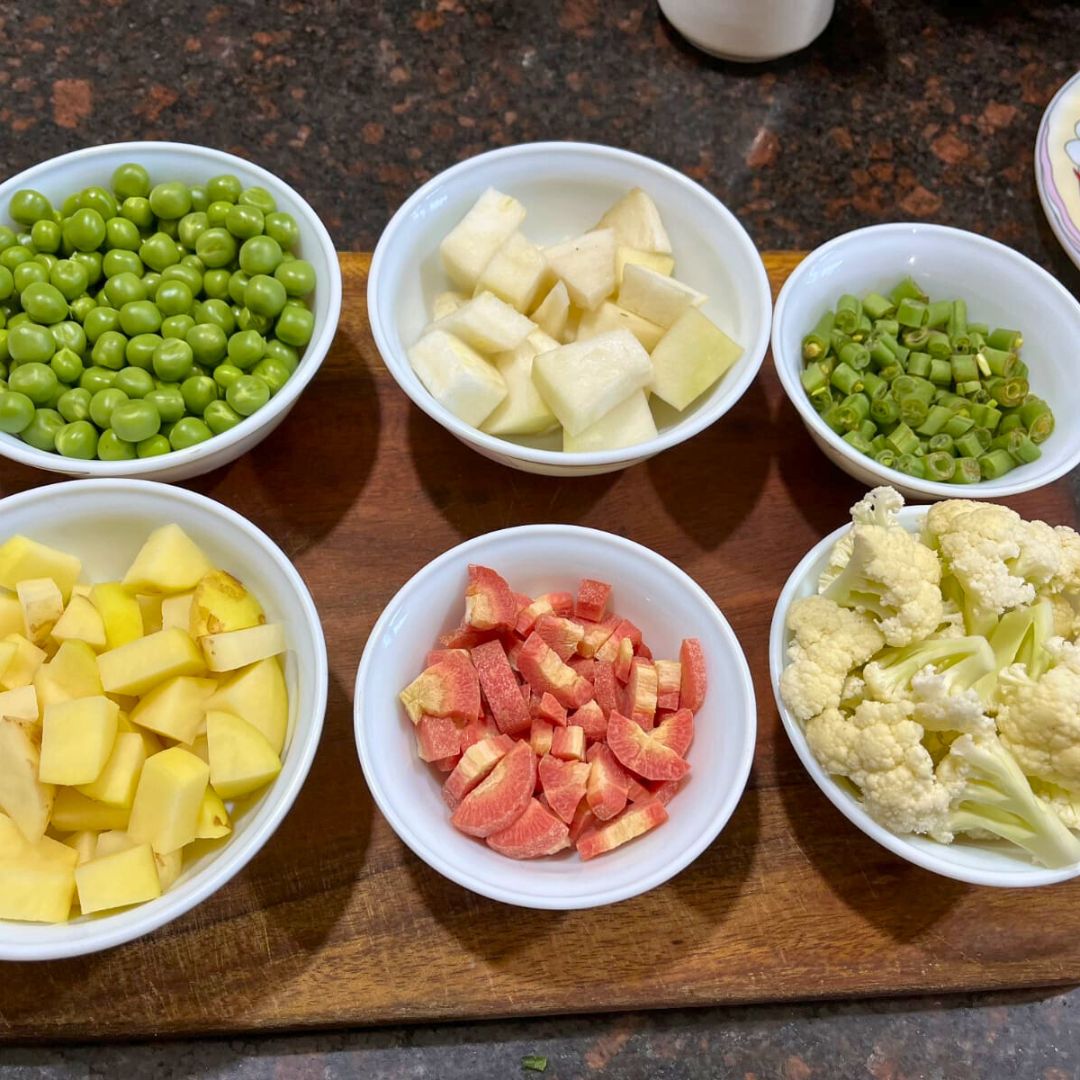 Image of Chop the vegetables (carrots, peas, bell peppers, potatoes, and cauliflower)...