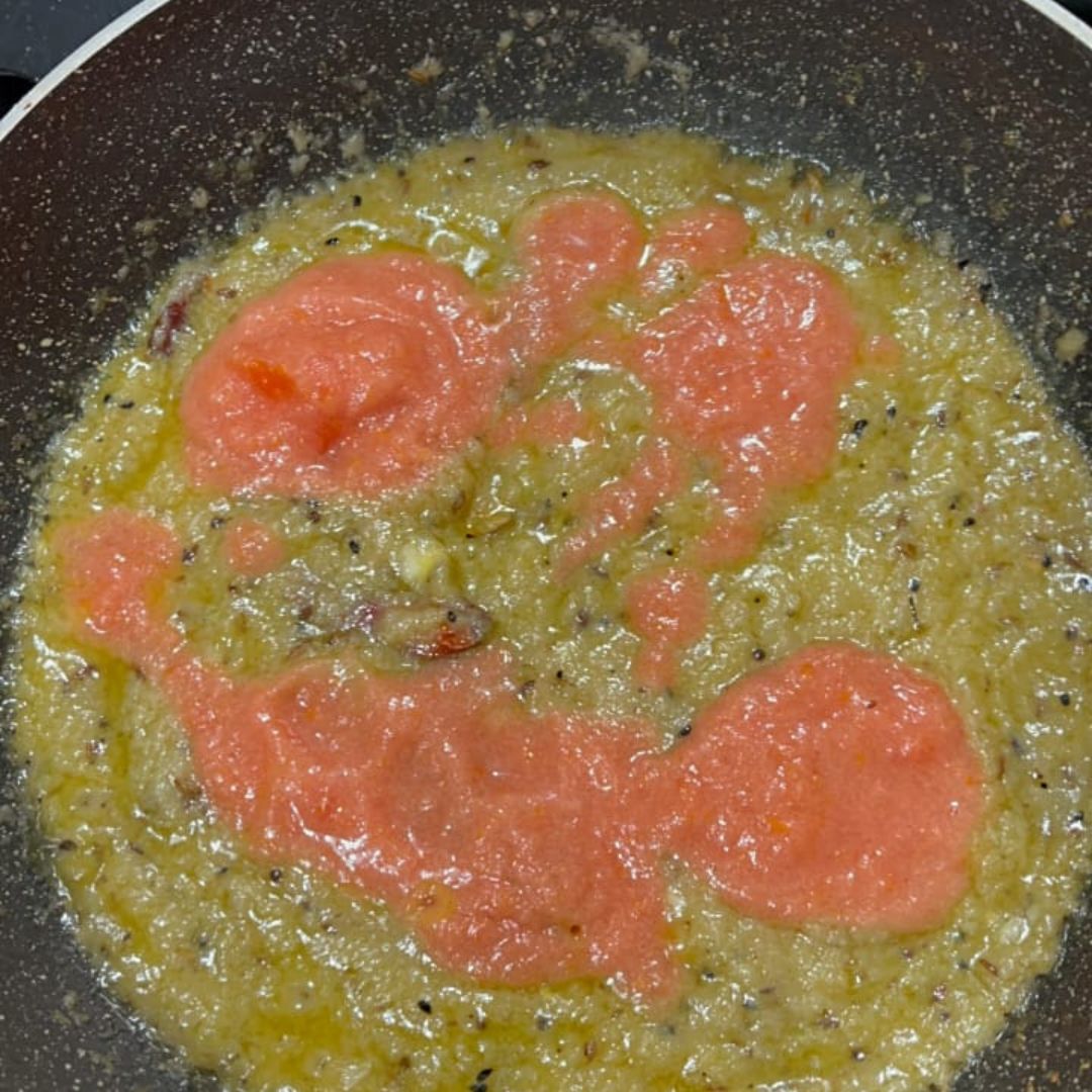 Image of Add tomato puree and cook until the oil separates.