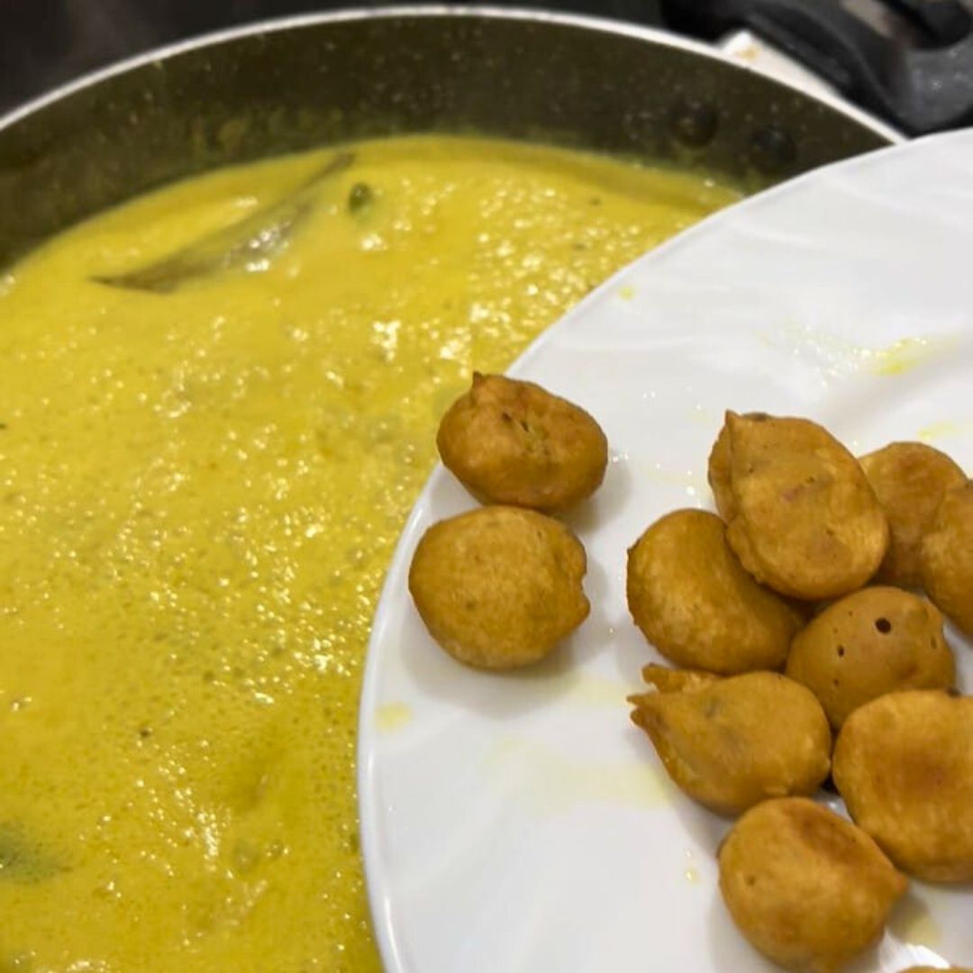 Image of Add the fried dumplings (bari) to the simmering kadi.