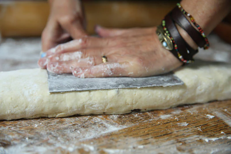 Image of Gently press down the rolled up dough with the dough...