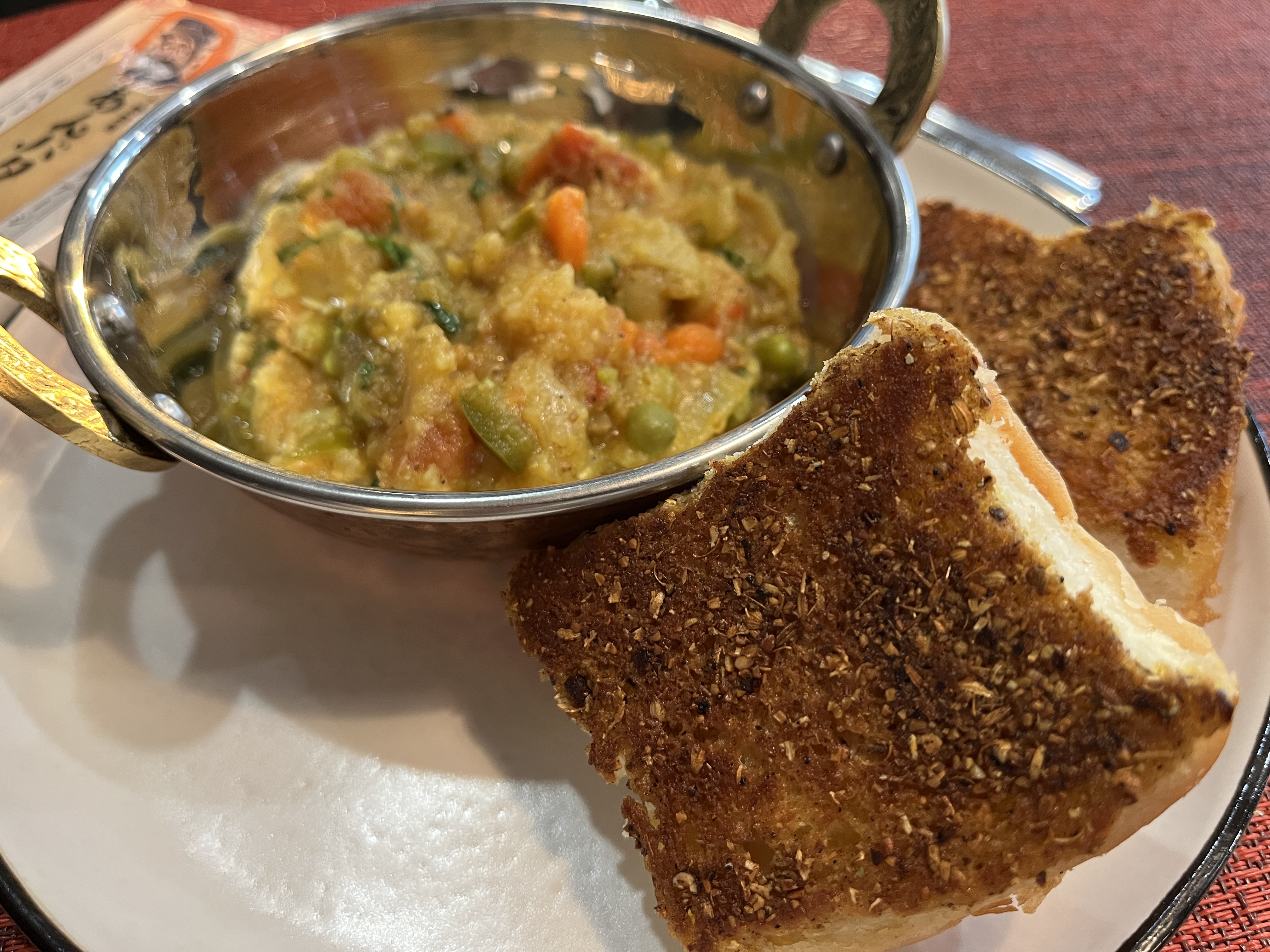 Image of Place a ladle of bhaji on a plate. Top the...