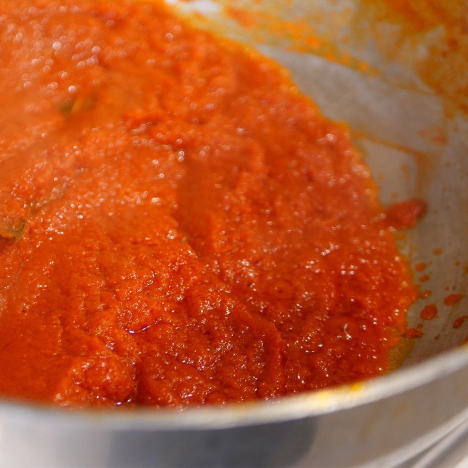 Image of Pour in the pureed tomatoes and simmer on low heat...
