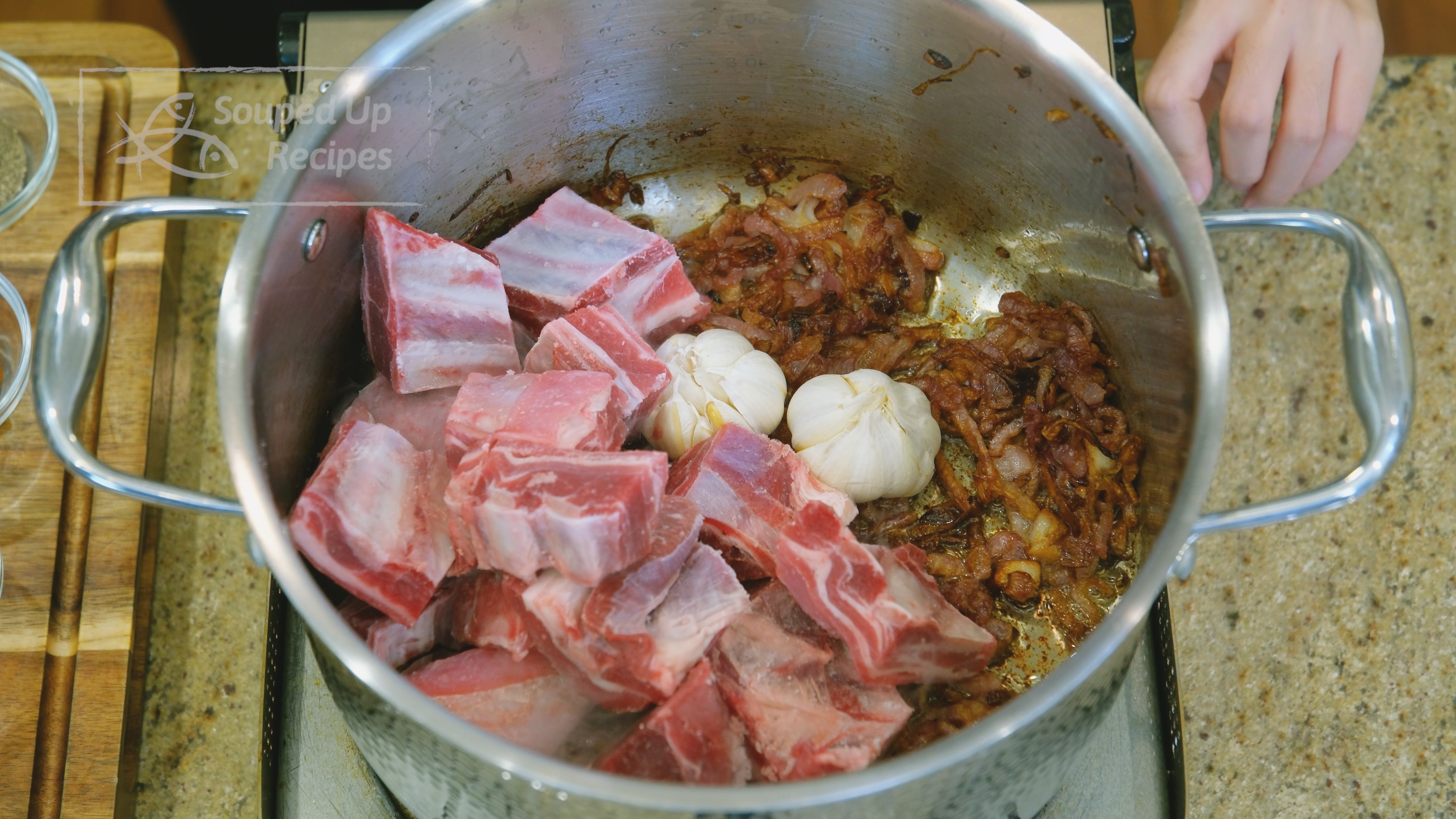 Image of Add the garlic bulbs, carrot sticks, and bone-in lamb meat...