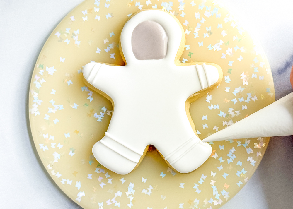 Image of Using the white outline consistency royal icing, add the line...
